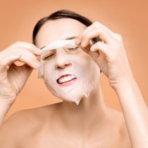 Woman Removing White Face Mask